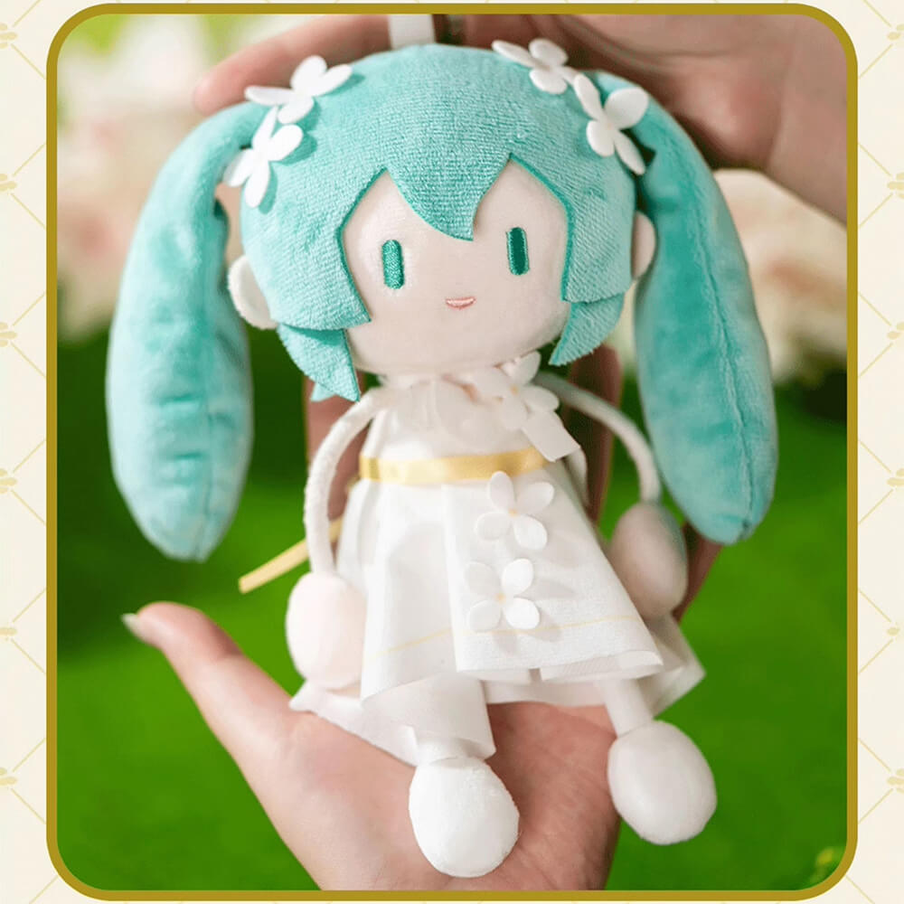 Plush Miku with turquoise hair and white dress held in hands against a blurred green background