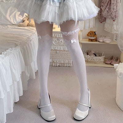 White kitten stockings with lace details worn by a girl in a room with white furniture and decor.