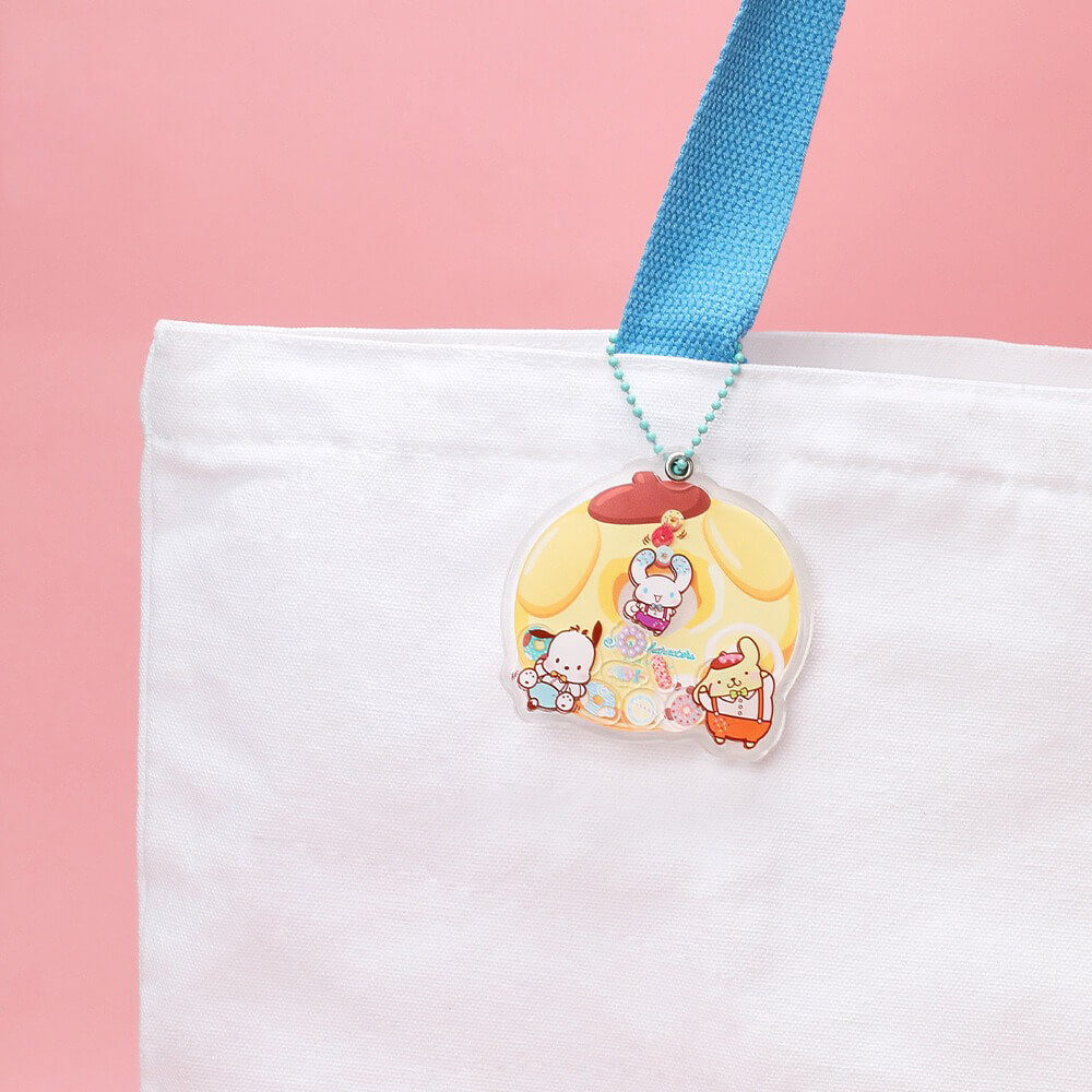 playful-pompompurin-donut-shaped-acrylic-charm-attached-to-a-white-canvas-bag